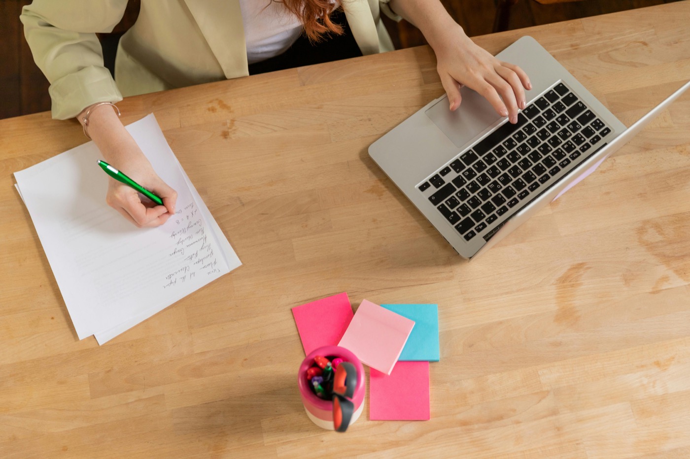 Focused writing and planning setup with laptop and paper notes